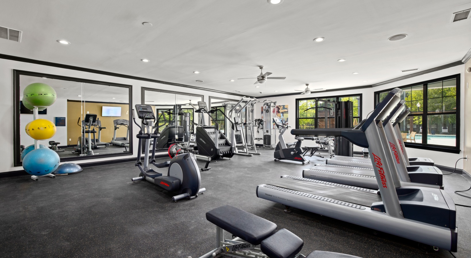 a gym room with exercise equipment and mirrors at The Landon