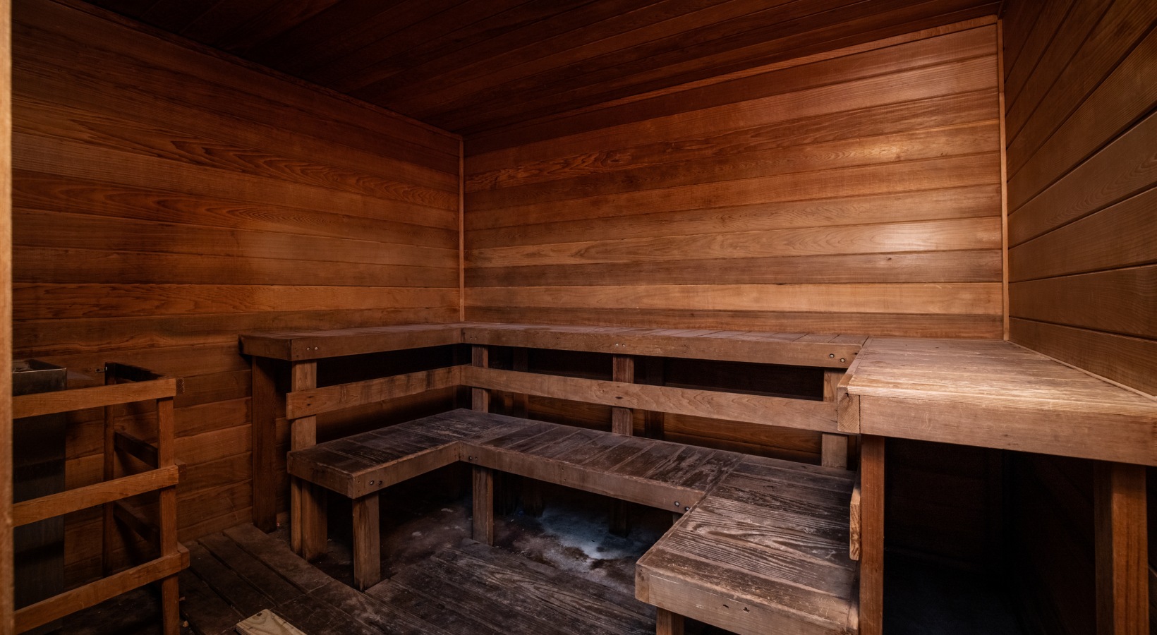 a wooden sauna with benches and a door at The Landon