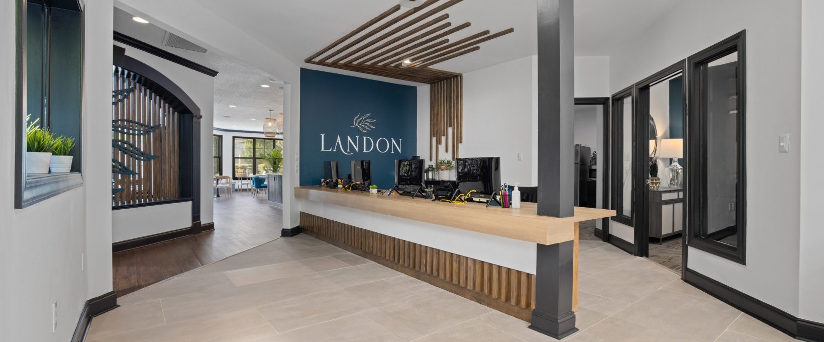 the reception area of a hotel with a large sign on the wall at The Landon