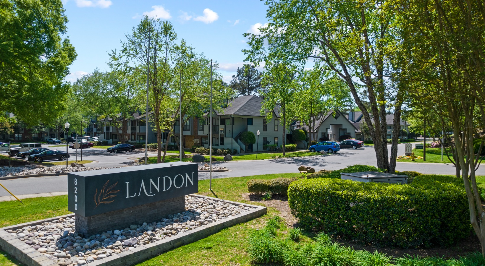 the sign for larson's apartment complex in the middle of a park at The Landon