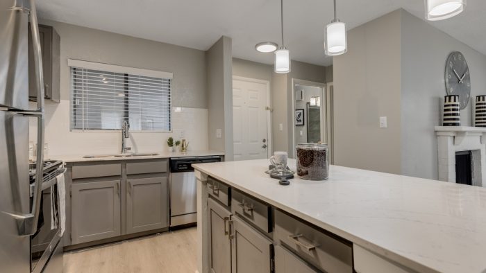 a kitchen with stainless steel appliances and white cabinets at The Landon